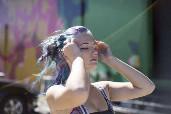 Woman brushing back colour treated hair - Cabelo Hair Co.